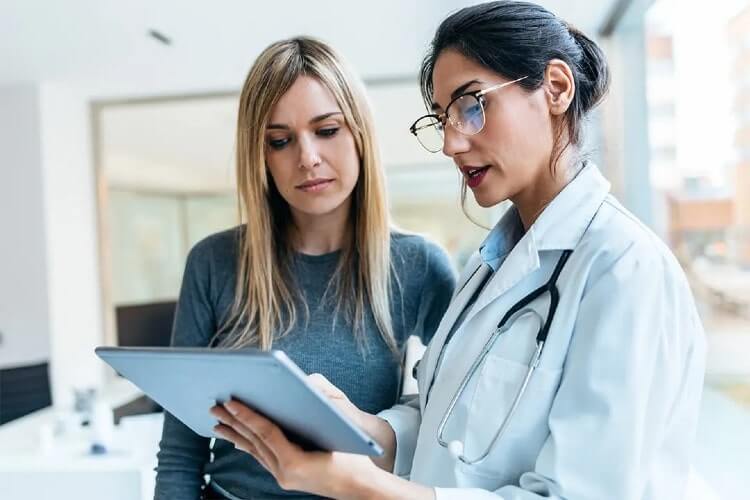 two women looking at a tablet