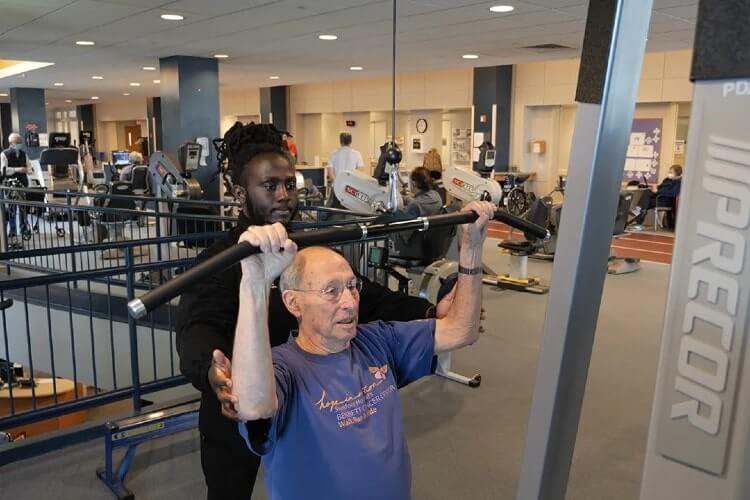 trainer assisting a man workout