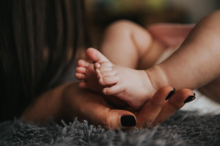 baby feet over hands