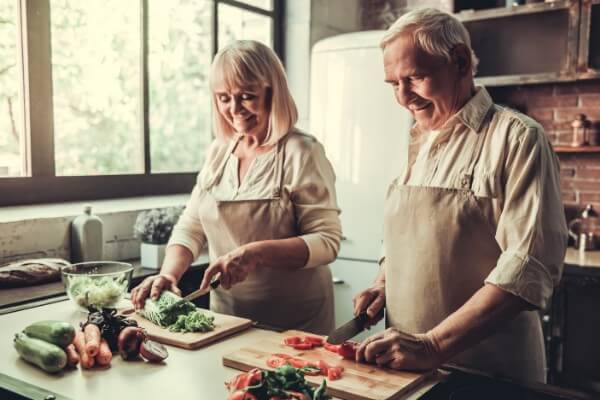 A man and woman chopping vegetables