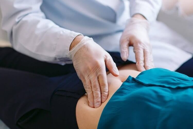 nurse checking a patients abdomen