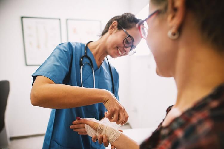 a nurse bandaging a patients wrist