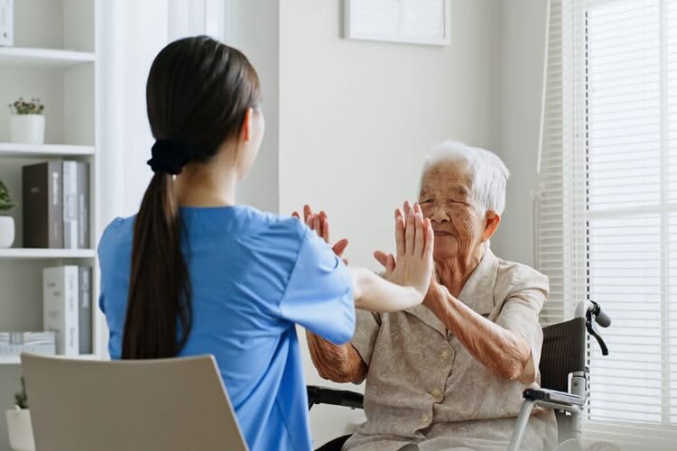 nurse entertaining an elderly patient