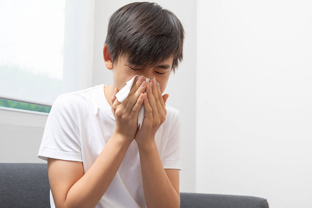 Boy blowing nose