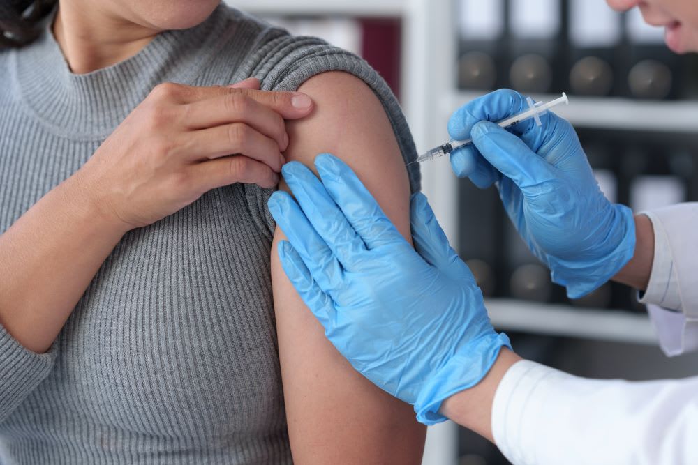 A woman receives a vaccination from her doctor