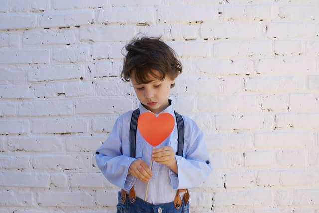 Young boy holding paper heart