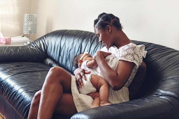 Mom breastfeeding baby on sofa